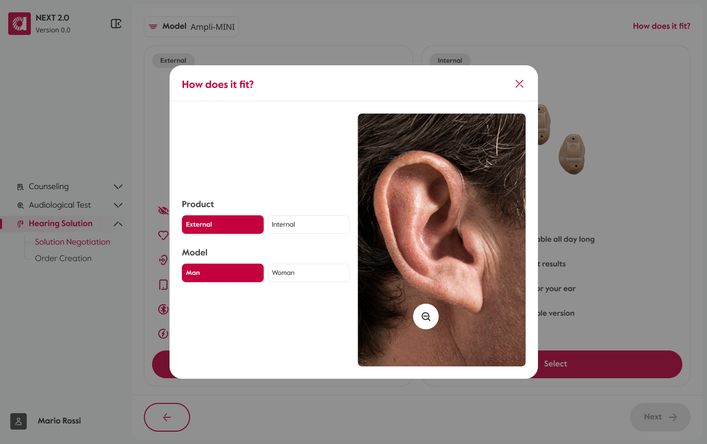 The same overlay zoomed in: the model's ear fills the preview, with the external aid tucked behind it and hard to make out even at this scale. The product and model selectors stay alongside, and the control now offers zoom out.